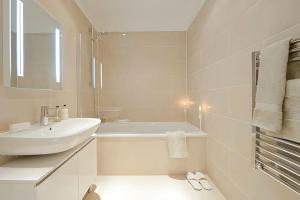 ein weißes Badezimmer mit einem Waschbecken und einer Badewanne in der Unterkunft Luxury, Spacious 2 Bed flat in London in London