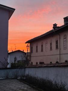 um pôr-do-sol atrás de um edifício numa cidade em Palazzo Rosso em Lesegno