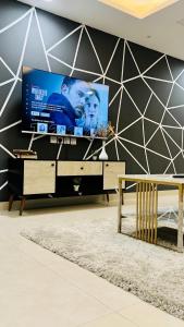 uma sala de estar com uma televisão de ecrã grande numa parede em One Bed Appartment in GoldCrest Mall and residency DHA Lahore em Lahore
