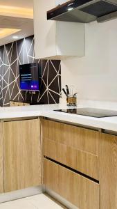 a kitchen with wooden cabinets and a tv on the counter at One Bed Appartment in GoldCrest Mall and residency DHA Lahore in Lahore