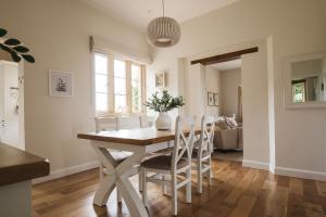 a kitchen and dining room with a table and chairs at The Cotswold Hideaway - Boutique Cottage in Long Compton