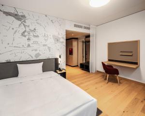 IntercityHotel Paderborn في بادربورن: غرفة نوم بسرير ابيض وتلفزيون