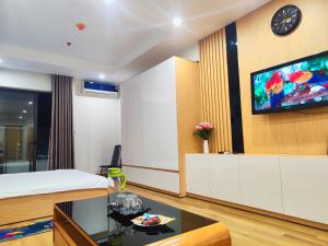 una camera d'albergo con letto e TV a parete di Căn hộ view biển Travel Green- TMS Quy Nhơn a Quy Nhon