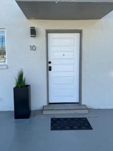 Una puerta blanca con una alfombra delante. en Modern Hideaway en El Paso