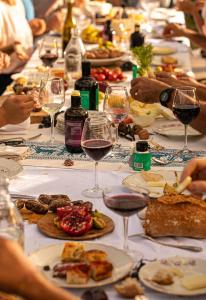 długi stół z kieliszkami wina i jedzeniem w obiekcie Villa Polvese Luxury Estate w mieście Magione