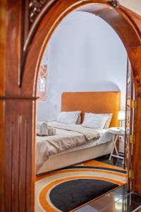 a bedroom with a large bed with an archway at MangoHouse in Maputo