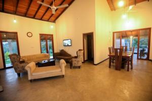 a living room filled with furniture and a table at Plantation Villa in Baddegama