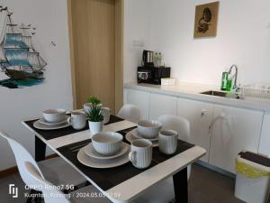 una cocina con una mesa con platos y un barco en la pared en Kuantan Imperium seaview cityview by Avenzee en Kuantan