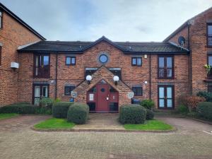 una casa de ladrillo rojo con puerta roja en Quiet Enclave on the marina, Free Parking, en Hull