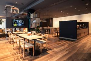 a restaurant with tables and chairs and a kitchen at IntercityHotel Paderborn in Paderborn +24 photos