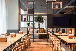 a restaurant with tables and chairs and a couch at IntercityHotel Paderborn in Paderborn