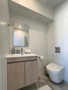 uma casa de banho com um WC, um lavatório e um espelho. em MARTIN Nicosia City Suites em Nicósia