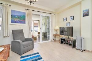 a living room with a chair and a television at Casa Venus in Salobreña