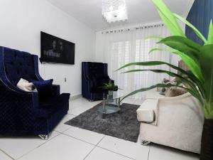 uma sala de estar com duas cadeiras e um vaso de plantas em 3 BR apartment - READY for your stay WIFI Pool Great Location em Santiago de los Caballeros