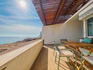 balcón con mesa, sillas y vistas al océano en Apartamentos Sol Naixent, en L'Ametlla de Mar