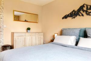 Schlafzimmer mit einem Bett und einem Wandspiegel in der Unterkunft Gemütliche Ferienwohnung mit Terrasse und Bergblick in Inzell
