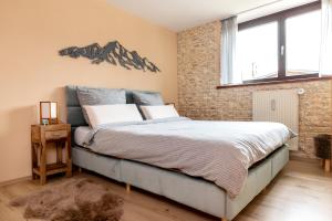 sypialnia z łóżkiem i ceglaną ścianą w obiekcie Gemütliche Ferienwohnung mit Terrasse und Bergblick w mieście Inzell