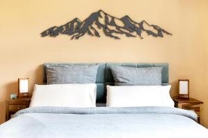 ein Schlafzimmer mit einem Bett mit einem Wandbild der Berge in der Unterkunft Gemütliche Ferienwohnung mit Terrasse und Bergblick in Inzell