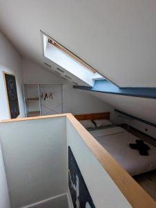 a dorm room with a bed and a skylight at Maison atypique avec garage 2 roues - Proche Gare in Le Havre