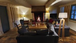 a living room with a couch and a table and a fireplace at Magnifique ferme landaise 12 couchages in Allons