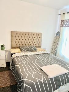 a bedroom with a bed with a black and white comforter at Homestay in Waltham Abbey