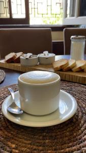 uma chávena de café num prato numa mesa com pão em Casa mia em Mar del Plata