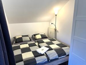 um quarto com uma cama xadrez em preto e branco em Ferienwohnung Nele em Hillstett