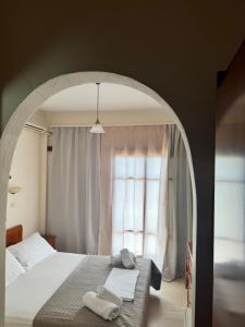 - une chambre avec un grand lit et une fenêtre dans l'établissement Olive Grove, à Plakias