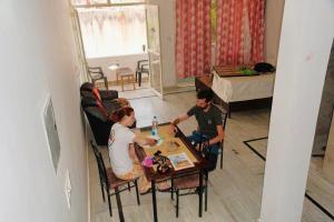 a man and woman sitting at a table in a room at Backpackers Karma Home stay in Khajurāho