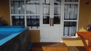 a white door in a room with windows at Dins Nature Villa in Elgiriya