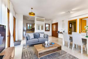 a living room with a couch and a table at 1 bedroom Apartment Pyrgos with beautiful sea and sunset views, Aphrodite Hills Resort in Kouklia
