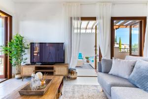 uma sala de estar com um sofá e uma televisão em 1 bedroom Apartment Pyrgos with beautiful sea and sunset views, Aphrodite Hills Resort em Kouklia