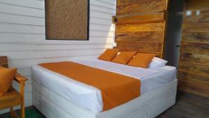 a bed with orange pillows in a room at Dins Nature Villa in Elgiriya