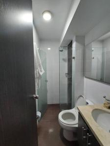 y baño con aseo, ducha y lavamanos. en Apartaestudio piso 19 con vista panoramica, en Sotomayor