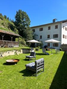 einen Garten mit Stühlen, einem Tisch und einem Gebäude in der Unterkunft Exclusive Apartment Tassenbacherhof in Strassen