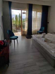 1 dormitorio con 1 cama, 2 sillas y ventana en The Morning Sky hotel en Leh
