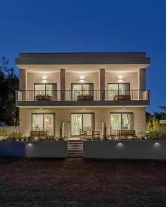 un grand bâtiment avec des tables et des chaises devant dans l'établissement The 8 Suites, à Polychrono
