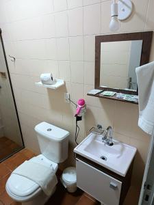 a bathroom with a toilet and a sink and a mirror at NC Hotel in Bragança Paulista