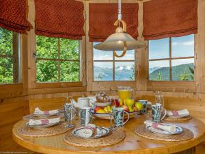 einen Tisch mit Teller mit Lebensmitteln in einem Zimmer mit Fenstern in der Unterkunft Chalet Haute Vue in La Tzoumaz