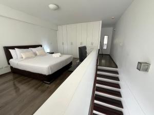 a bedroom with a bed and a staircase leading up to it at Elegant 1Bed Duplex in Lima