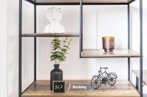 a shelf with a vase and a bike on a table at Luxury Apartment By Mechanical Properties Short Lets and Serviced Accommodation Epsom with Parking in Epsom