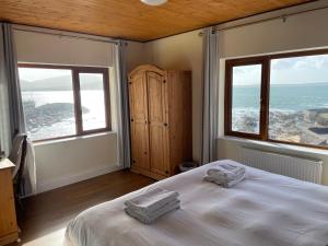 um quarto com duas toalhas numa cama com duas janelas em The Coastguard House @ Tigh T.P. em Ballydavid