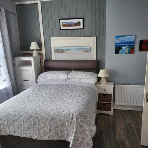 a bedroom with a bed and two tables and two lamps at Eask View Dingle - Room Only in Dingle