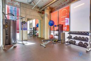 a gym with dumbbells and weights in a room at Beachfront Condo -ROOFTOP POOL OceanView Balcony in Hollywood
