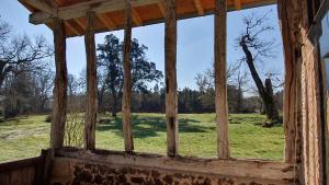 an open window in an old building looking out at a field at Magnifique ferme landaise 12 couchages in Allons