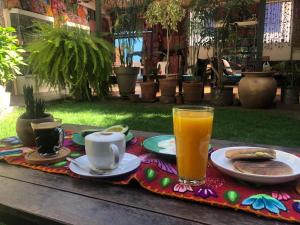 a table with a breakfast of coffee and orange juice at CASA AUGUSTA in Pisac
