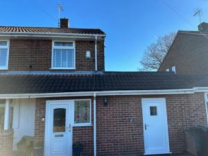 a brick house with white doors and a roof at Bestwood Lodge Studio in Nottingham