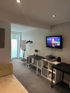 a living room with a flat screen tv on the wall at Bestwood Lodge Studio in Nottingham