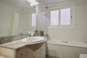 uma casa de banho com um lavatório, uma banheira e um espelho. em Homenfun Barcelona Sants estación em Barcelona