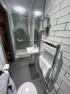 a bathroom with a toilet and a shower and a sink at The New Hobbit Hotel Rooms in Halifax